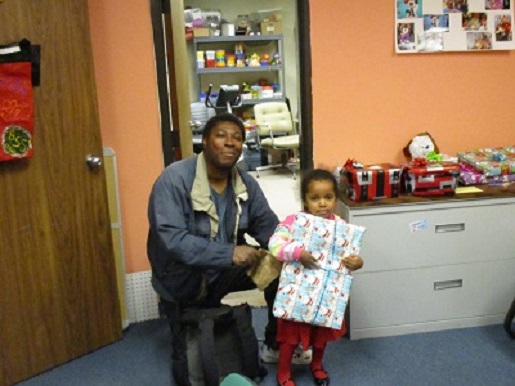 A father and his daughter holding her Christmas present